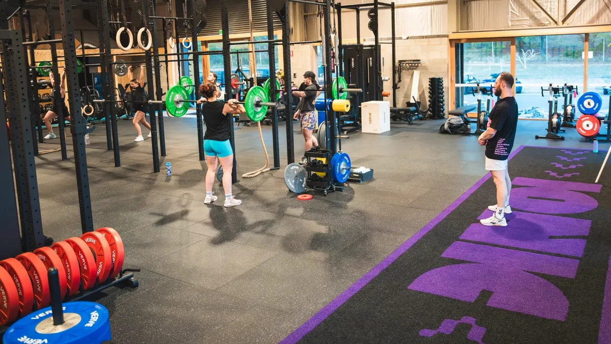 Members and coaches working across a fitness club floor