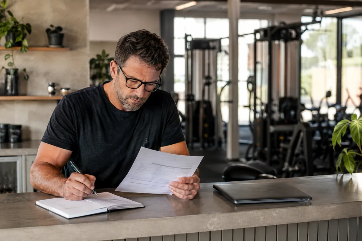 Gym owner checking a billing statement and noting questions